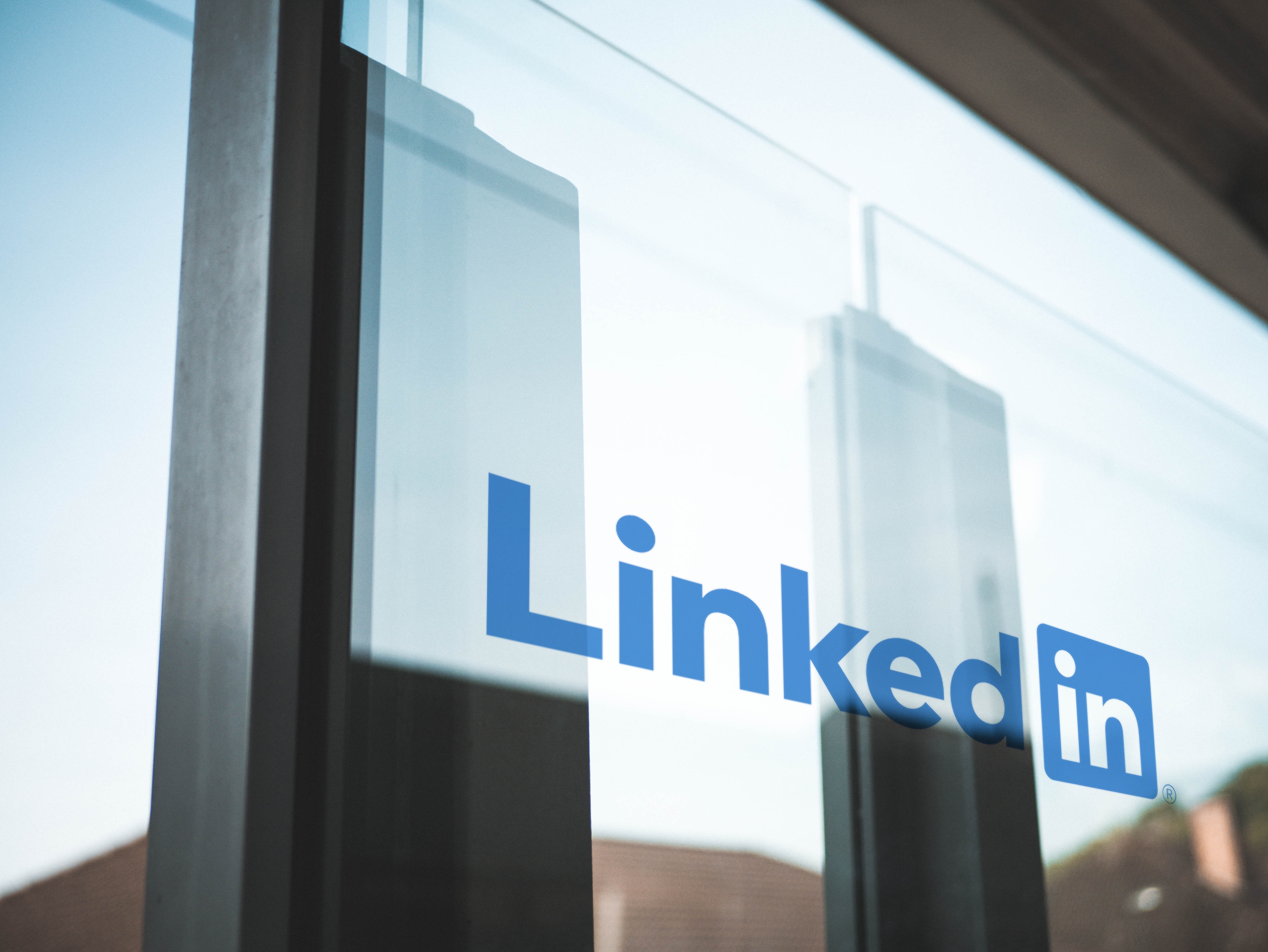 LinkedIn logo on a glass panel against a scyscraper background